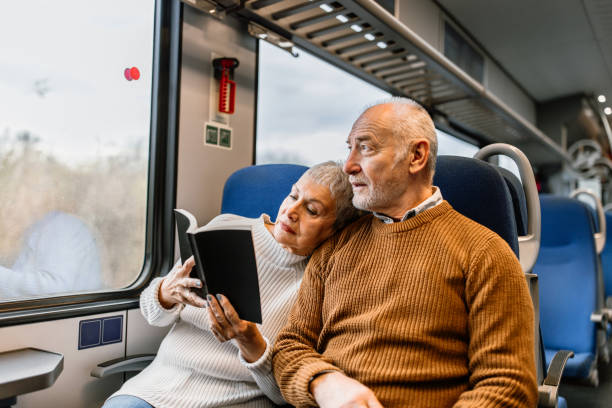 Senior couple enjoying long ride while napping and reading book