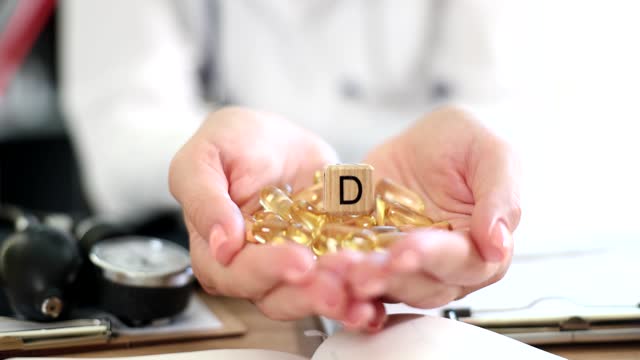 Doctor nutritionist holding vitamin D tablet closeup