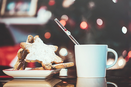 christmas cookies and milk for santa on a defocus christmas tree background