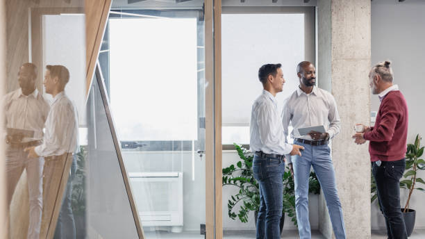 istock Colleagues talking in front of an office cubicle 1448413593