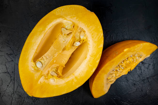 istock Cut pumpkin on black stone table, top view, slice of fresh pumpkin 1448414728