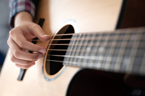 istock Woman's hands playing acoustic guitar, close up 1448415472