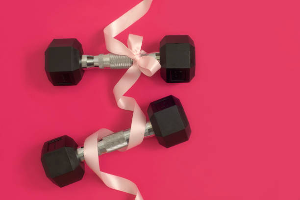 istock Dumbbells with bow tie on pink magenta 1448417044