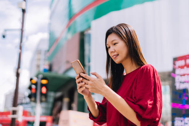 istock woman surfing the net, using smartphone in city. 1448420516