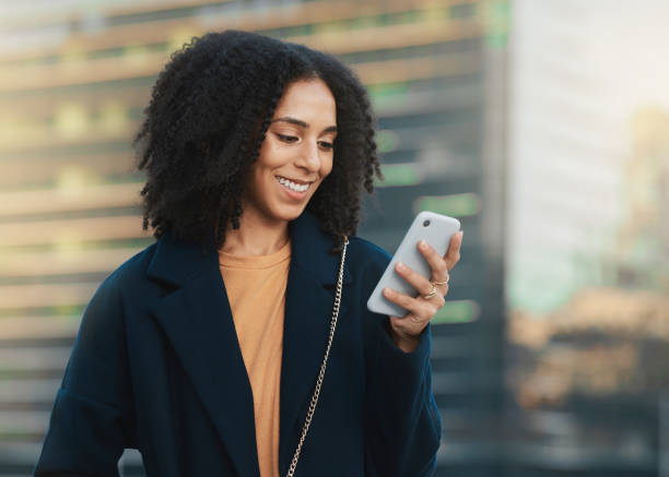 teléfono, redes sociales y comunicación con una mujer negra de negocios escribiendo un mensaje de texto en la ciudad. móvil, networking y contacto con una empleada feliz leyendo un correo electrónico en una ciudad urbana - business blurred motion text messaging defocused fotografías e imágenes de stock