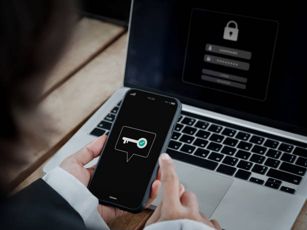 istock Two-factor authentication (2FA) concept. Key icon on smart phone screen in hand near laptop computer for validate password page, Identity verification, cyber security technology. 1448426553