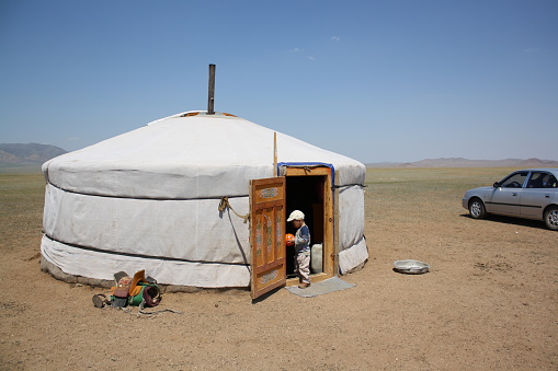 A boy with his ball in the nomadic tent of the lonely Atar steppe, Tuv region in Mongolia.