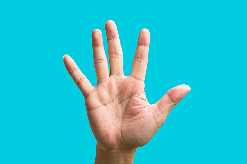 Palm of a male hand showing five fingers pointing up. On blue background.