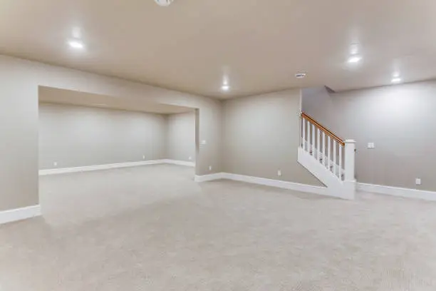 Light colored carpet with plenty of LED wafer lights to make this basement bright