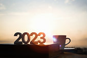 The brightly rising sun, the 2023 New Year's sunrise, and books and coffee