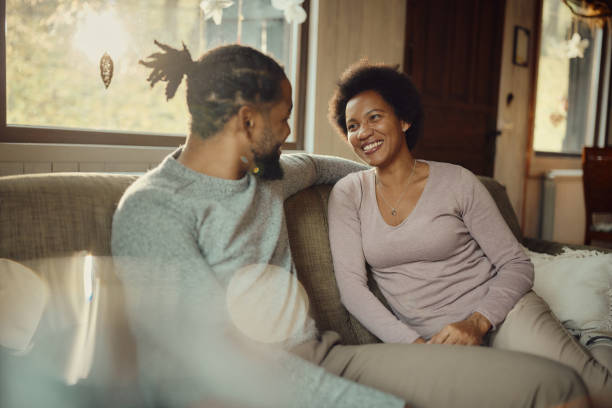 istock Happy black couple talking on sofa at home. 1448454855