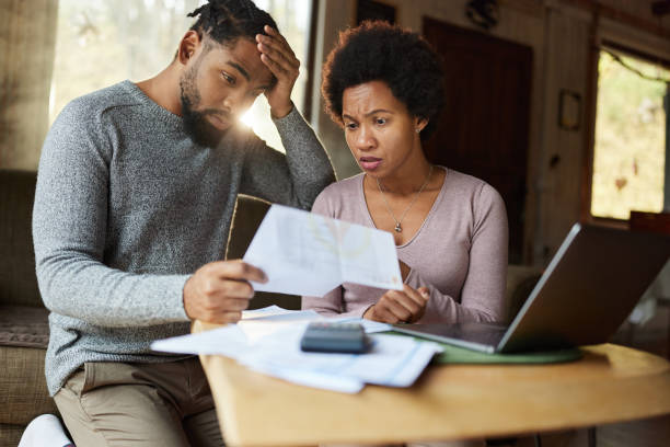 istock Worried black couple having problems with their financial bills at home. 1448455550