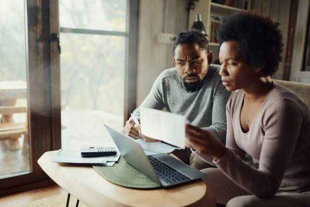 casal negro pagando suas contas em um computador em casa. - home finances debt tax finance - fotografias e filmes do acervo