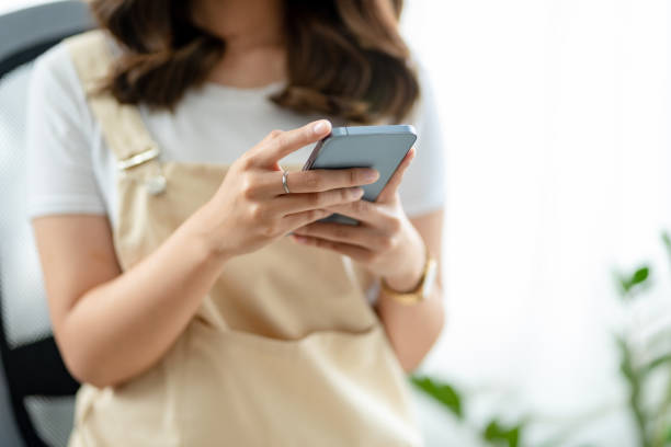istock Woman using mobile phone to send text , work or play social media. 1448457048