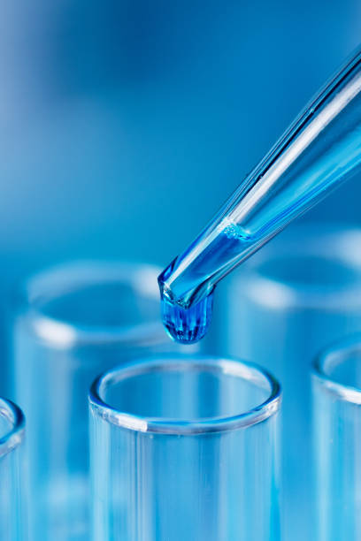 istock Test tubes with blue liquid water samples and pipette over blue background. 1448459559