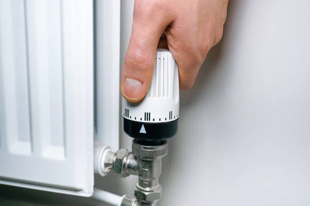 istock Radiator thermostat being turned with one hand 1448460295