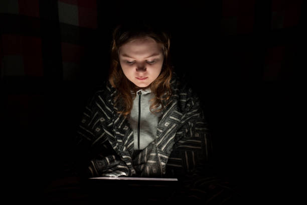 istock Blackout. Girl using a tablet pc in a dark room 1448460341