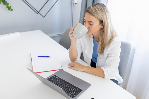 Woman taking a coffee break when working on her computer