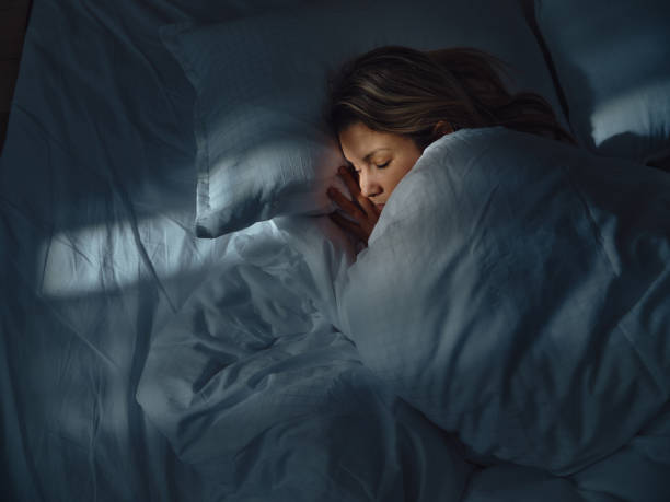 vista superior de una mujer relajada durmiendo en la cama por la noche. - mujer durmiendo en la noche fotografías e imágenes de stock