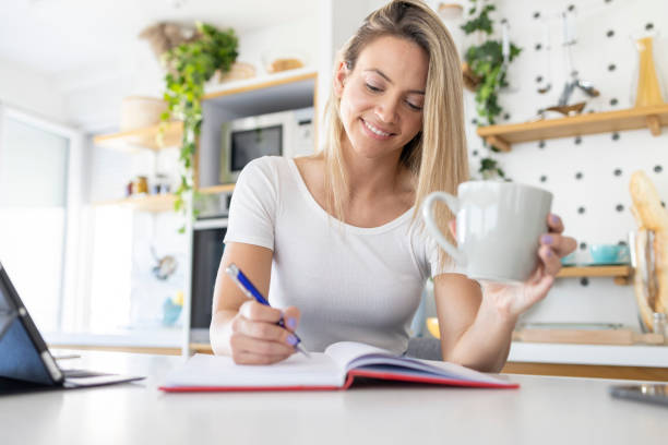 istock Happy young woman smiling when taking notes during coffee break 1448465224