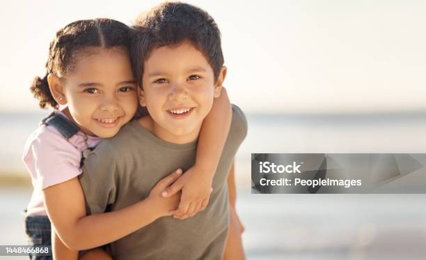 Happy Smile And Portrait Of Siblings At The Beach Hugging And Playing While On Summer Vacation Happiness Ocean And Brother Giving His Sister A Piggyback Ride While On A Seaside Family Holiday Stock Photo - Download Image Now