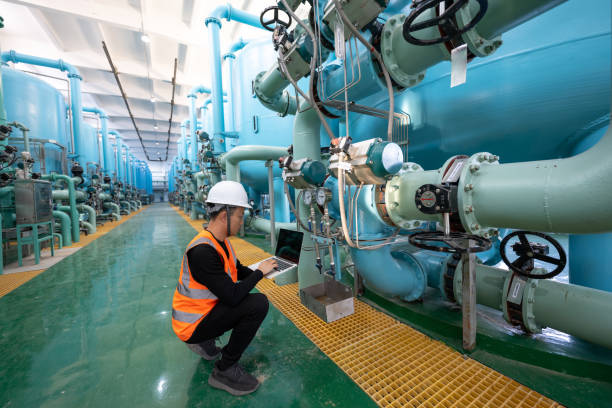 chemical plant engineer checking equipment with laptop - farmaceutische fabriek stockfoto's en -beelden