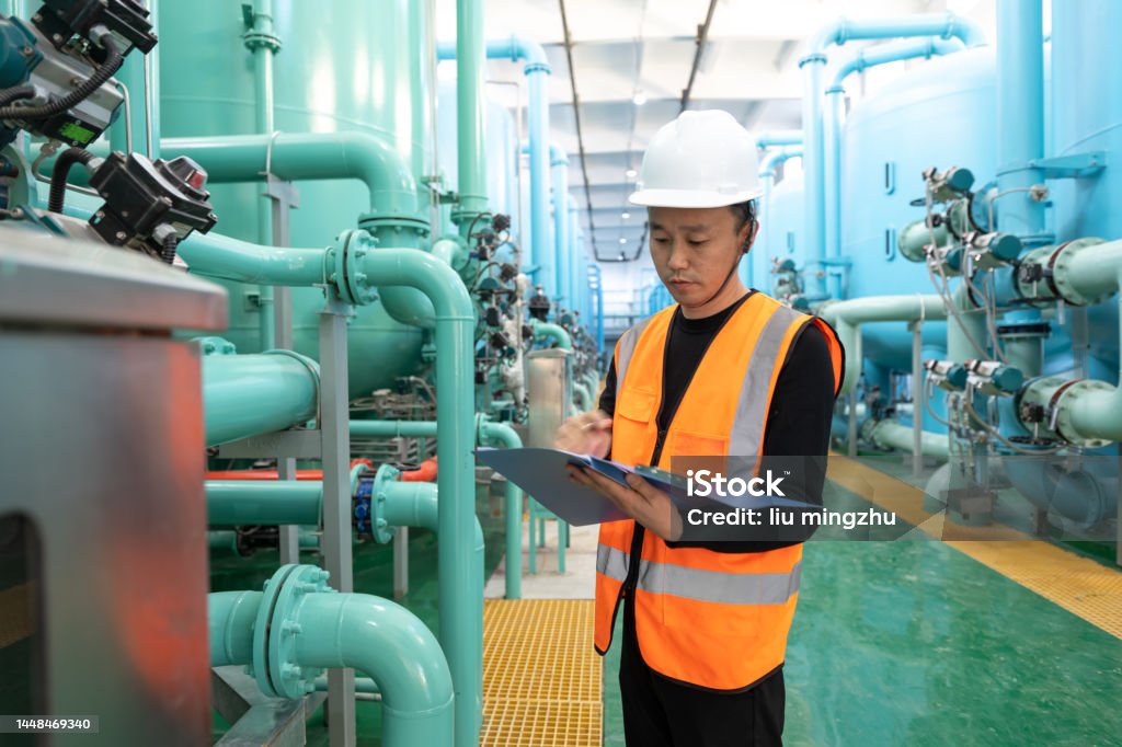 Technician in chemical plant holding folder in register equipment condition Male technician is checking equipment in a chemical plant factory in Fujian province, China 40-44 Years Stock Photo
