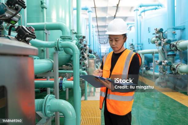 Technician In Chemical Plant Holding Folder In Register Equipment Condition Stock Photo - Download Image Now