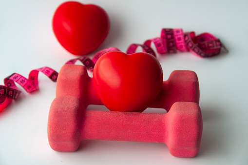 Heart shape on dumbbell with customizable space for text. Copy space and weight loss concept.