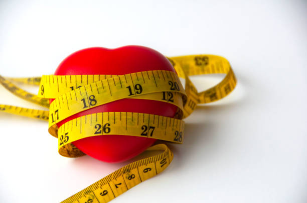 istock Heart shape wrapped with measuring tap with customizable space for text. Copy space and weight loss concept 1448469757