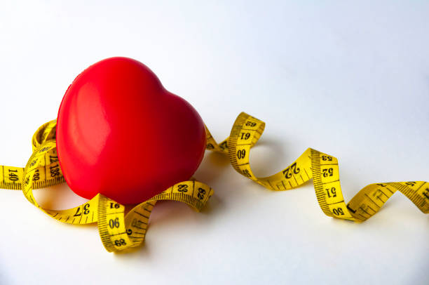 istock Heart shape with with measuring tap with customizable space for text. Copy space and weight loss concept 1448469758