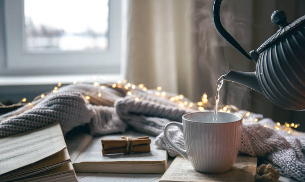 istock Cozy composition with a teapot, a cup and a book on a blurred background. 1448470738