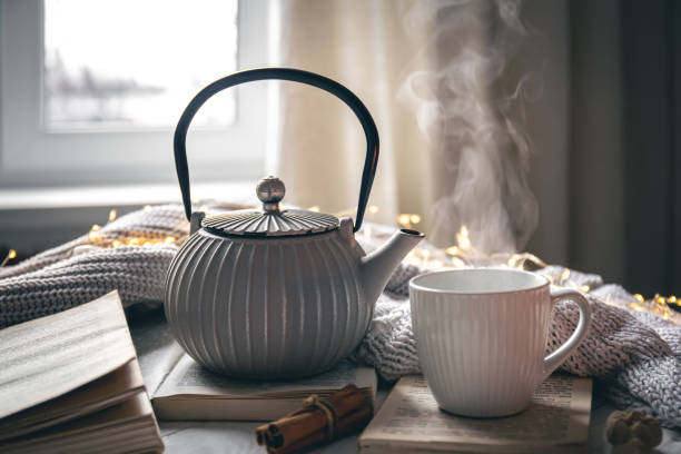 istock Cozy composition with a teapot, a cup and a book on a blurred background. 1448470741