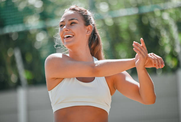 fitness, sport und frau, die ihre arme vor einem training oder training im freien in der natur ausstreckt. gesundheit, wellness und mädchen athletin macht eine aufwärmübung für ihre muskeln, gelenke und körper. - warming up fotos stock-fotos und bilder