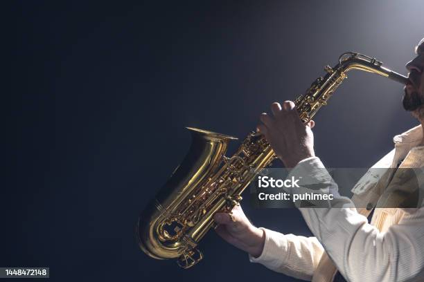 A European Man Plays The Saxophone In The Dark Stock Photo - Download Image Now - Jazz Music, Musician, Saxophonist