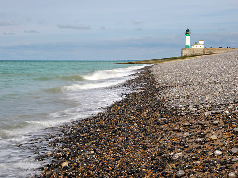 Pebble beach and Lighthouse of Le Treport, a commune in the Seine-Maritime department in Normandy, in northwestern France.