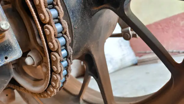 Detail of a motorcycle rear chain. Dirty bike, superbike chain close-up. Macro of motorcycle chain. Selective focus