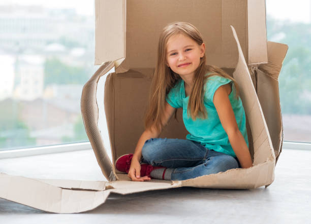 istock Smiling school girl in shipping box 1448473350
