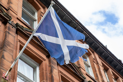 The Flag of Scotland in tatters outside a building in Fort William