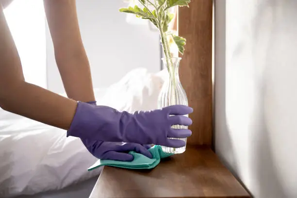 Hands of a woman mopping the bed