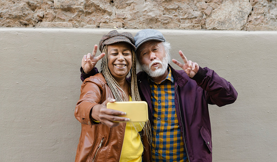Portrait of African american senior woman and asian mature taking a selfie with smartphone. Happy multiracial couple