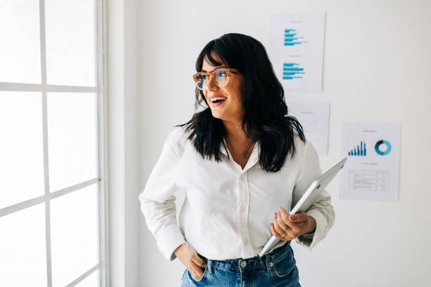 istock Female data analyst standing in an office and looking outside the window 1448474609