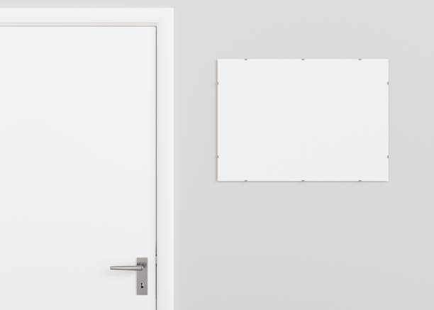 istock Blank white signboard hanging on the wall indoors. Empty signplate mock up. Name plate with copy space. Door sign template on entry in cabinet. Signage plate near to the door. Close up. 3D render. 1448475461