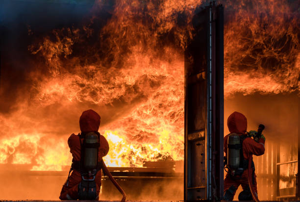 istock Firefighter Concept. Fireman using water and extinguisher to fighting with fire flame. firefighters fighting a fire with a hose and water during a firefighting training exercise 1448476622