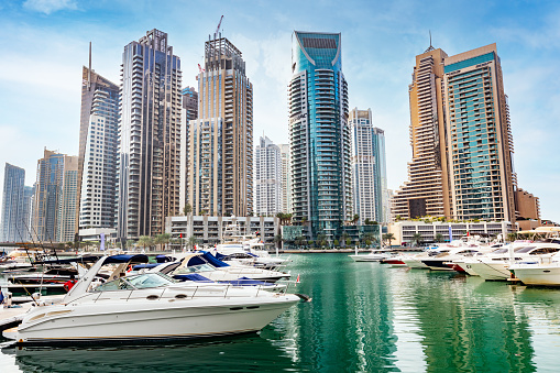 Dubai marina with yachts in UAE. High-rise residential buildings, business skyscrapers