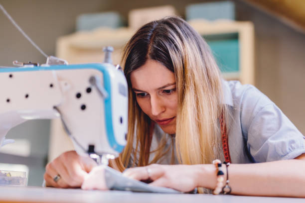 istock Seamstress dressmaker woman working with sewing machine in workshop 1448480087