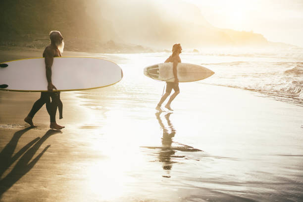istock Surfer father and son having fun while surfing on beach - Focus on guy face 1448480823