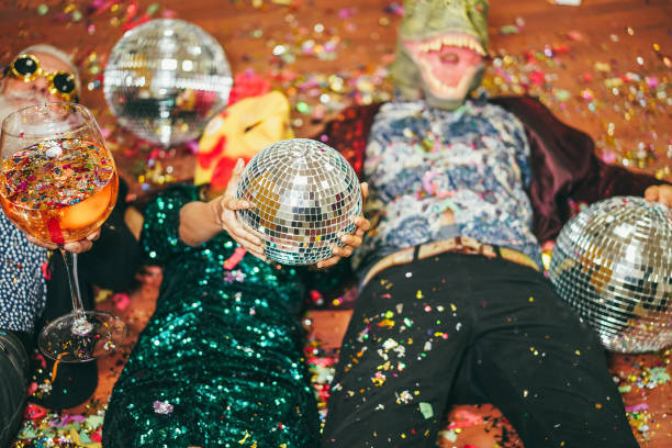 Crazy people celebrating carnival party inside nightclub - Focus on hands holding disco ball stock photo