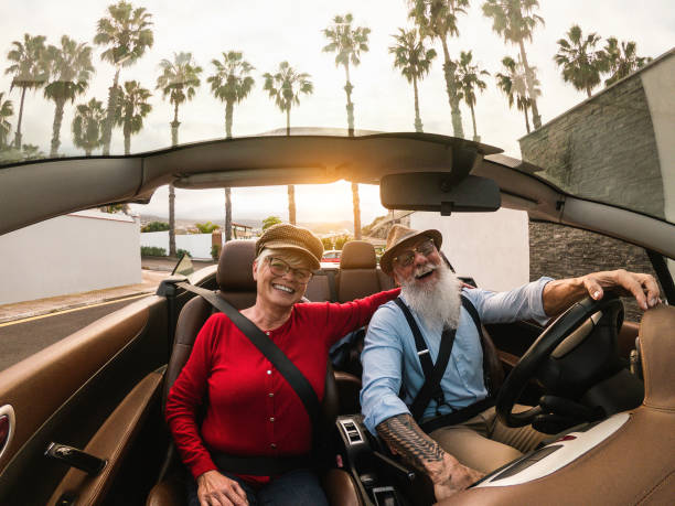 istock Happy senior couple having fun inside a convertible car during holiday vacation - Elderly travel concept 1448482046