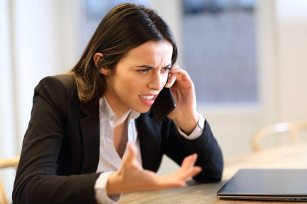 istock Angry businesswoman talking on phone at office 1448482585